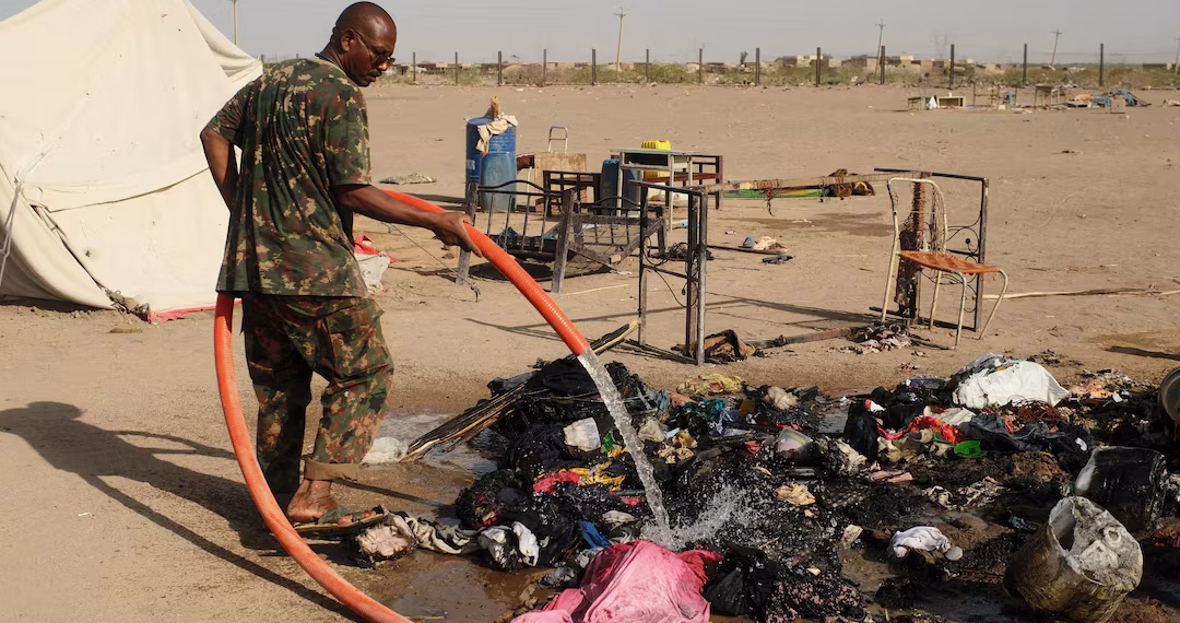 A soldier extinguishes a fire following a drone strike in Ad-Damar, Sudan, April 25, 2025.