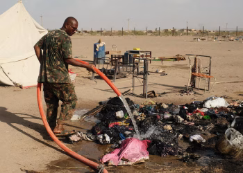 A soldier extinguishes a fire following a drone strike in Ad-Damar, Sudan, April 25, 2025.